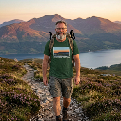 Man hiking with a backpack on a mountain path with a scenic view of the sleeping warrior mountains and water.